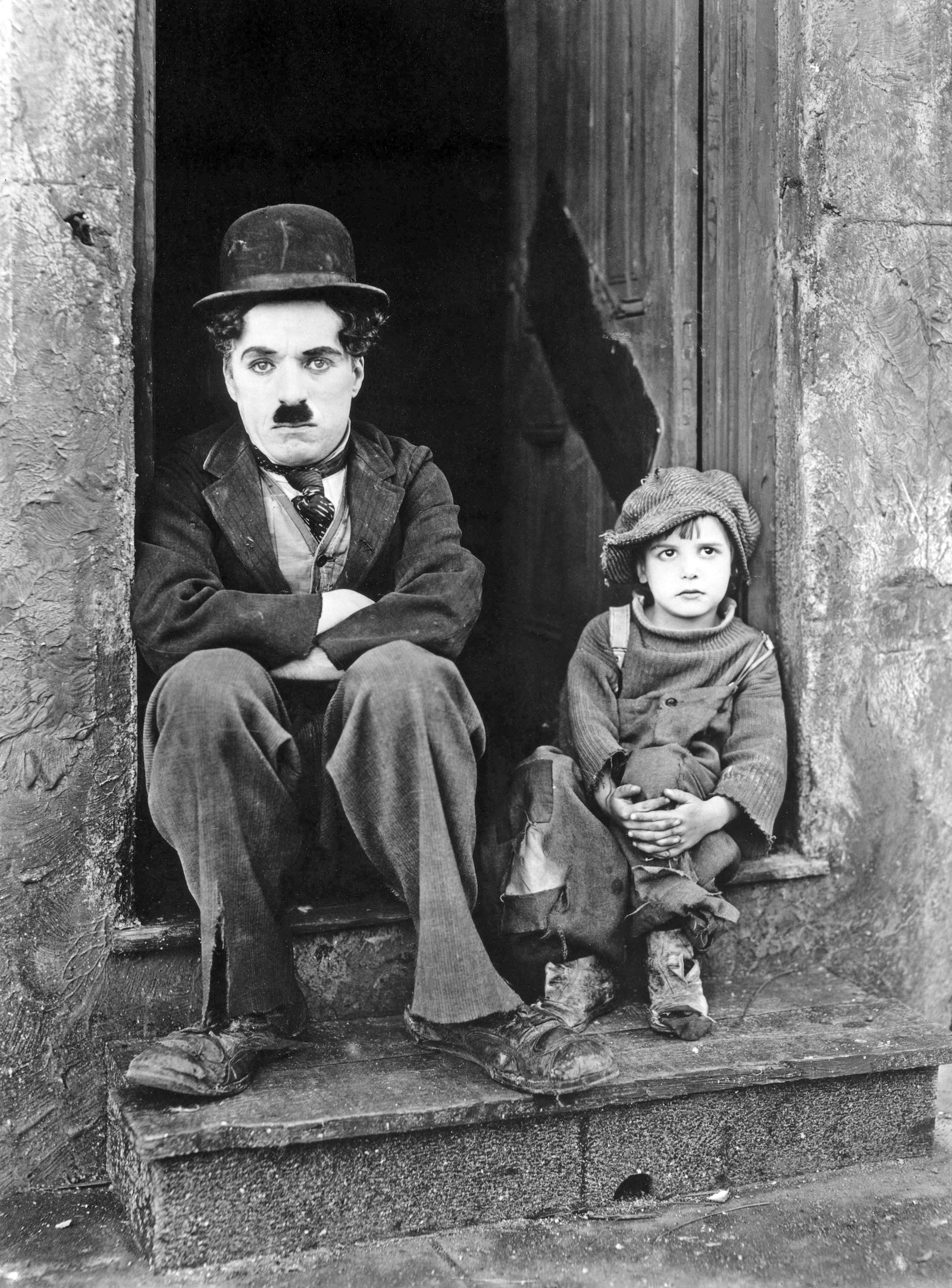 Jackie Coogan et Charlie Chaplin.  Photographie de publicité pour The Kid, 1921. Collection J. Willis Sayre de photographies théâtrales, Université de Washington.  Domaine public.